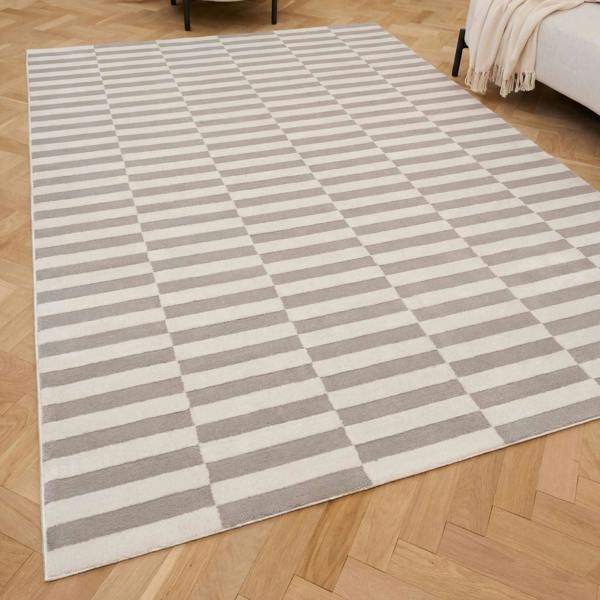 Checkered area rug with gray and white stripes on a wooden floor.