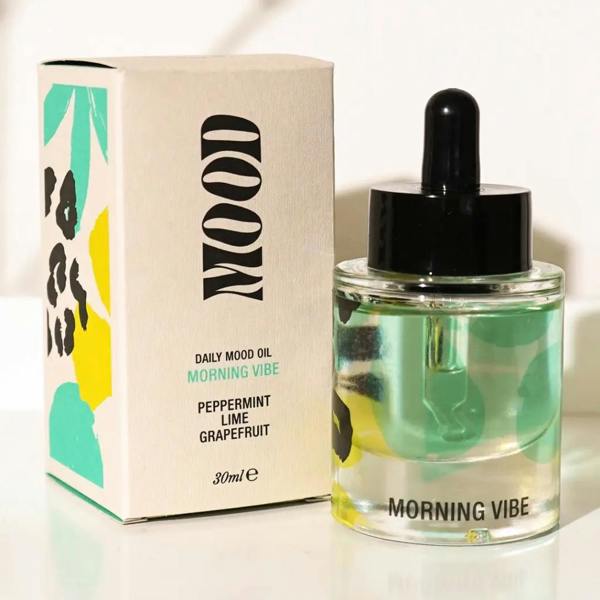 Morning Vibe Daily Aromatherapy Mood Oil glass bottle with dropper next to teal and yellow patterned box by Abode Home & Gifts
