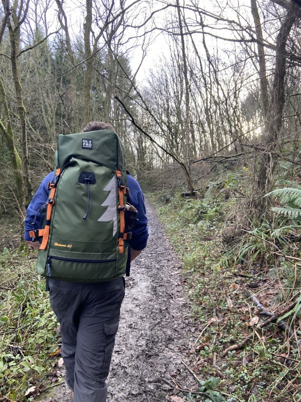 Walker walking through the forest with a 40L rucksack on his back.