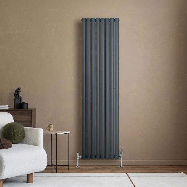 Sleek anthracite grey oval single column radiator mounted on a textured wall, complemented by modern valves and stylish decor