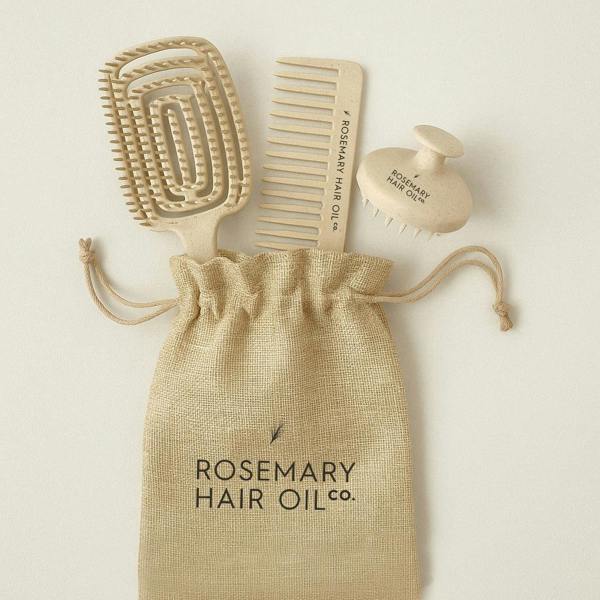 Set of hair care tools including a brush, comb, and bottle labeled 'Rosemary Hair Oil Co.' on a beige background. Rosemary Hair Oil Co Hair Growth Accessories Set featuring scalp massage brush, wide-tooth comb and storage pouch