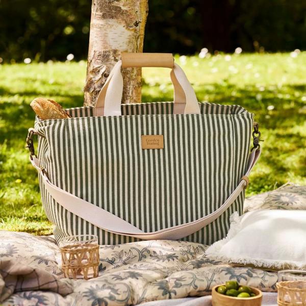 Moss green and cream striped canvas picnic bag on a garden blanket.