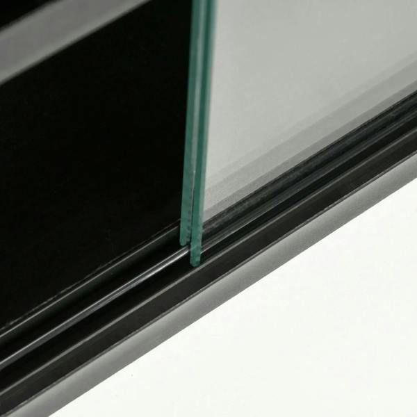 Close-up of black cabinet frame and glass door edge with clear tempered panel