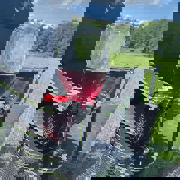 Henwick Padded Folding Camp Chair Orange & Black by OLPRO, close up of the wine glass holder with a glass of wine.