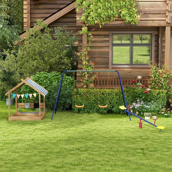 Wooden outdoor sandbox playhouse with striped canopy in a garden setting
