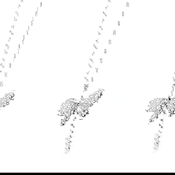 Silver dragonfly pendant necklace with cut outs in its wings, hanging on an adjustable silver chain.