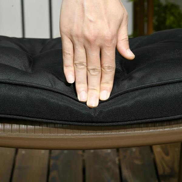 Black seat cushion being pressed by hand to show softness, ties visible