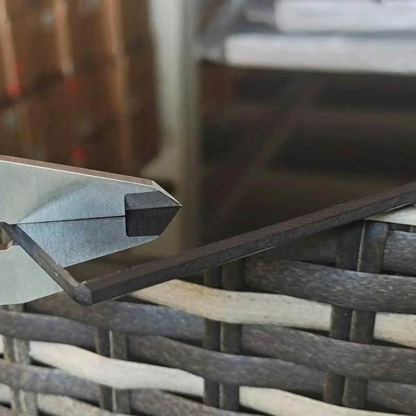 Rattan wicker armrest detail with dark support frame and woven texture.