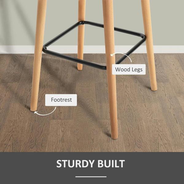 Close-up of beige bar stool base: light wood legs with black metal footrest