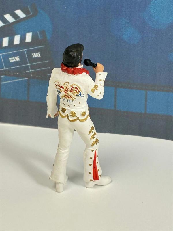 a toy figurine of a man holding a microphone