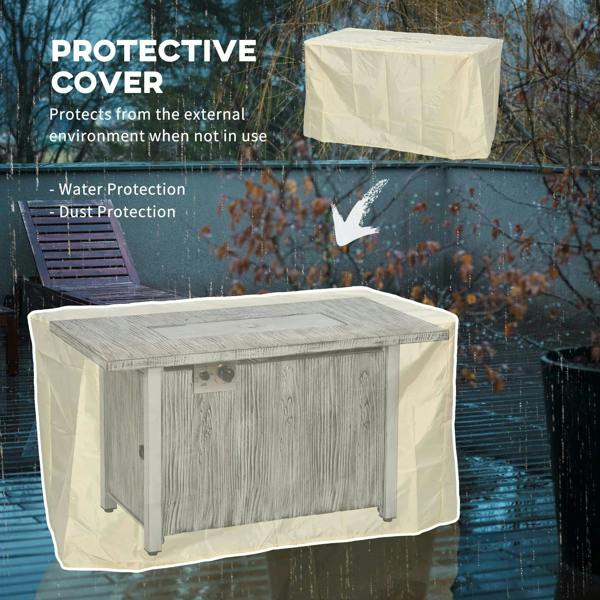 Grey gas fire pit table with protective cover draped over top