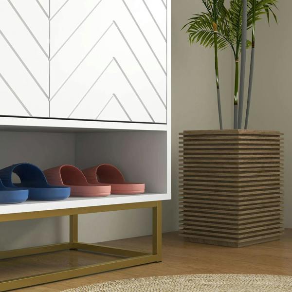 White shoe storage cabinet lower open shelf with shoes and gold-tone base frame