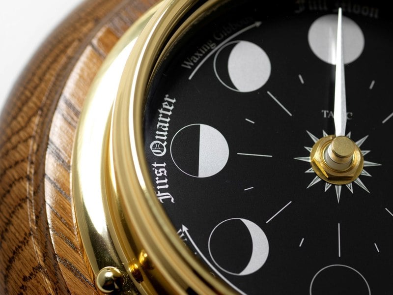 Prestige Brass Moon Phase Clock With a Jet Black Dial Mounted on a Solid English Dark Oak Wall Mount - TABIC CLOCKS