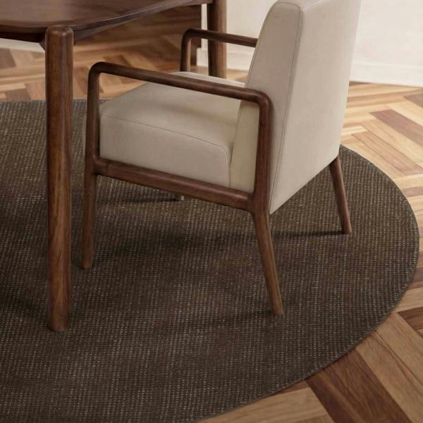 Chair with wooden frame and beige cushion on a round brown rug