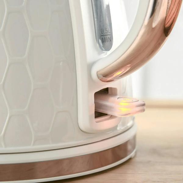 Cream electric kettle spout and copper-colored handle close-up
