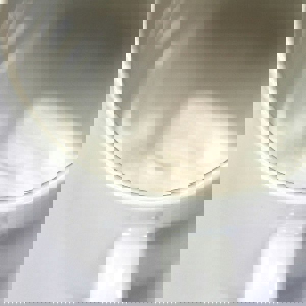 Close-up of glossy white polymer-coated ceramic mug with wide rim and sturdy handle.