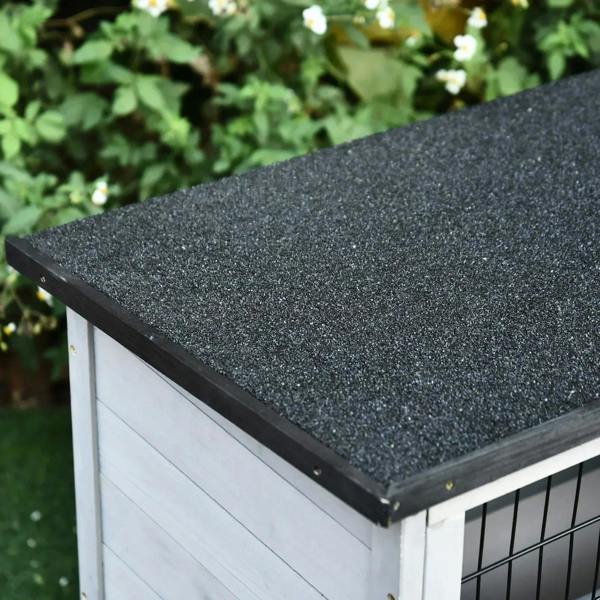 Dark textured asphalt-style roof on a white and grey wooden small animal hutch