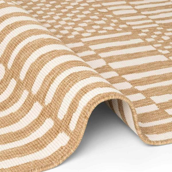 Close-up of a beige and white patterned rug on a plain background