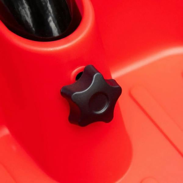 Red kids tricycle adjustment knob on black-and-red plastic frame detail