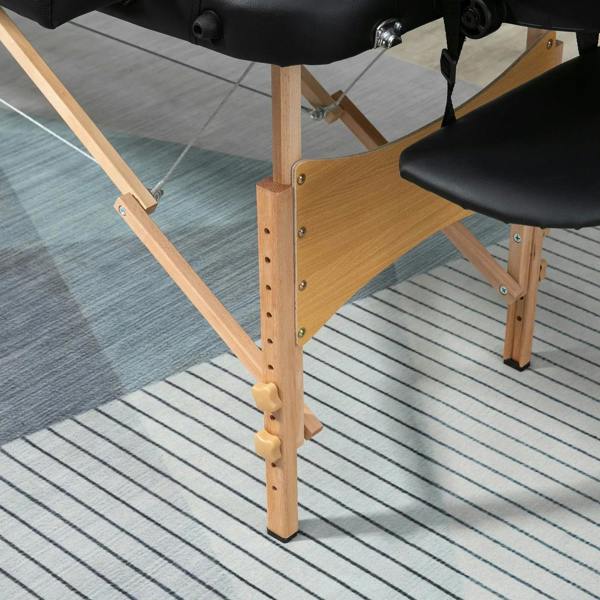 Black padded massage table with wooden frame and hinged folding legs