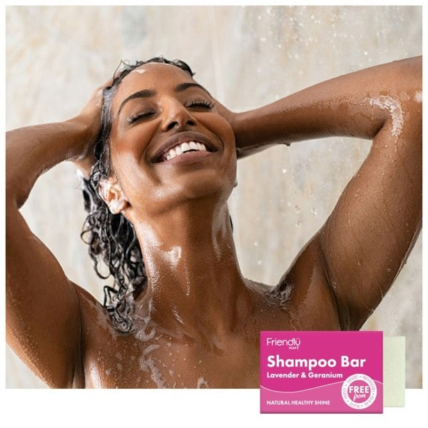 Woman washing her hair smiling in the shower