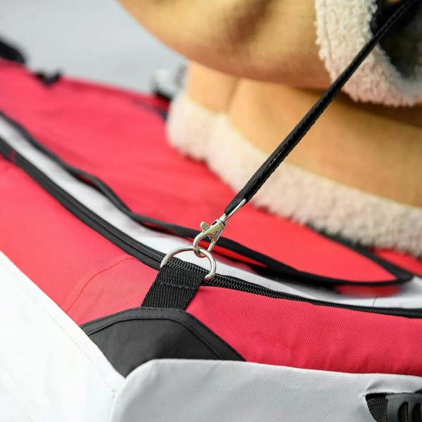 Padded red carrier interior with black straps and metal ring attachment point