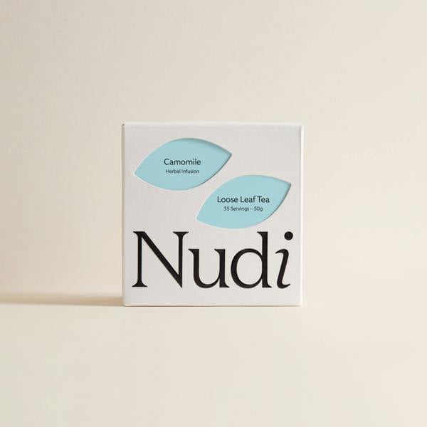 Nuditea camomile luxury tea box with soft blue and white label motifs.