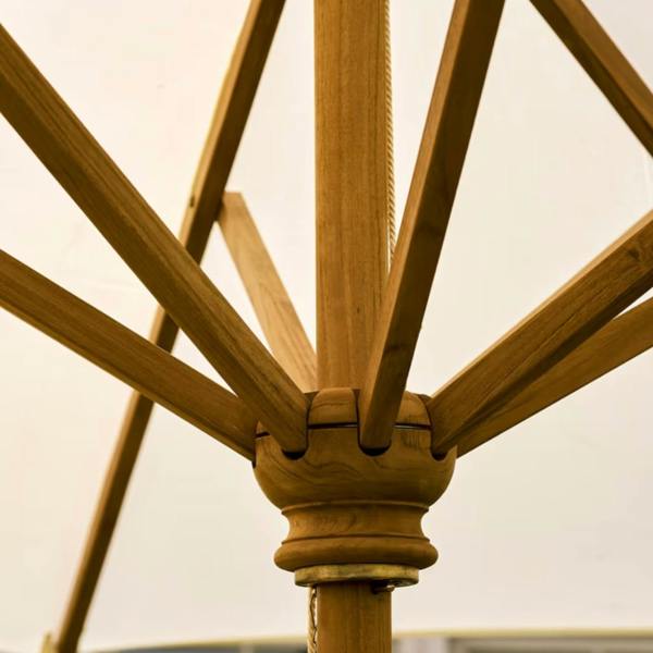 A detailed close-up shot of the handcrafted golden Indonesian teak wood collar, runner, and supporting rib mechanism beneath a white parasol canopy.
