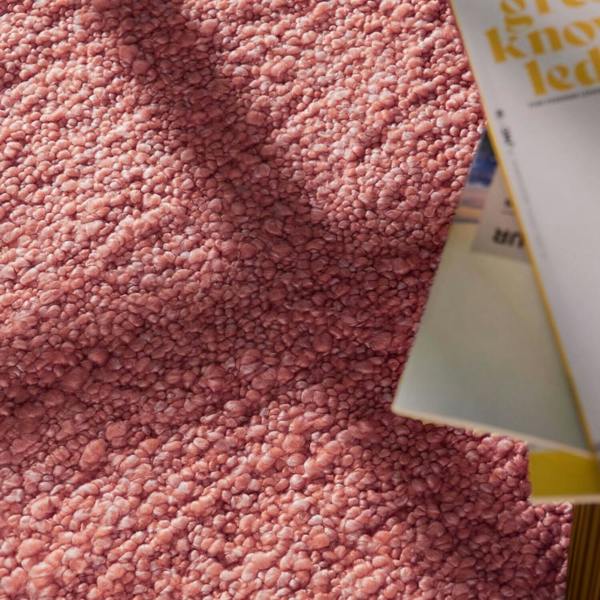 Pink textured surface with a tube of toothpaste partially visible