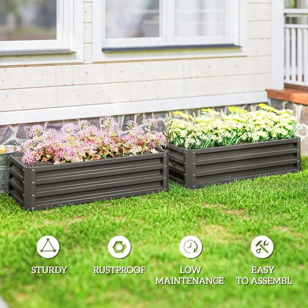 Two dark grey steel raised planter boxes with colorful flowering plants on grass