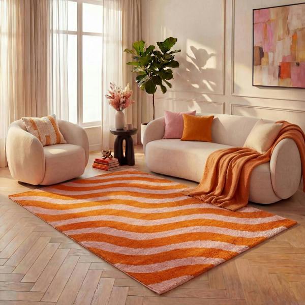 Living room with a striped orange and pink rug, beige sofa, and armchair.