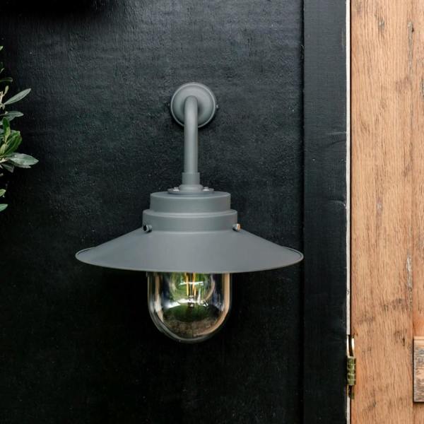 HMS Belfast inspired Charcoal deck light mounted on a black wooden wall next to a timber door.