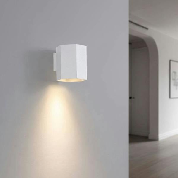 White interior LED wall downlight on a grey wall in a hallway of a modern house