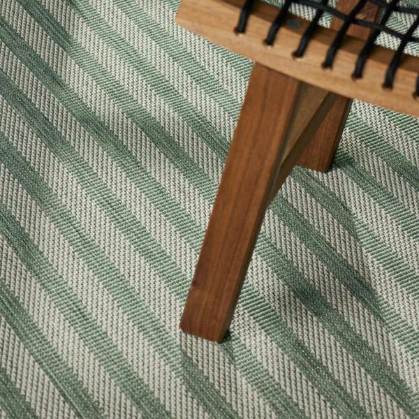 Wooden comb on a green and gray striped fabric background