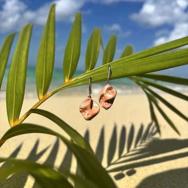 Shell earrings by LENAE, handmade in London with natural salmon coloured shells and displayed on castaway beach.