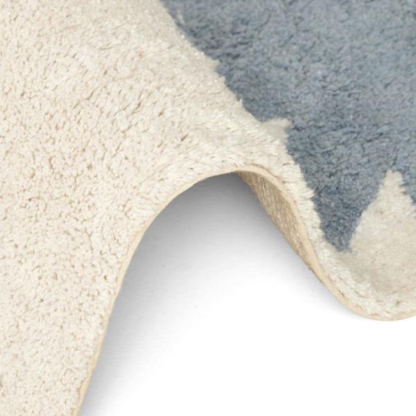 Close-up of a textured rug with a neutral color palette.