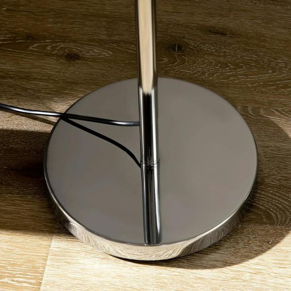 Round silver base of a crystal floor lamp with chrome center pole