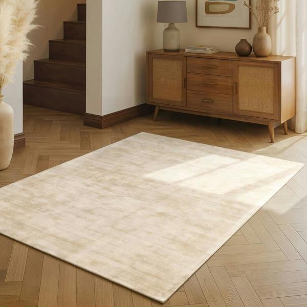 Beige rug on a wooden floor with a wooden sideboard in the background