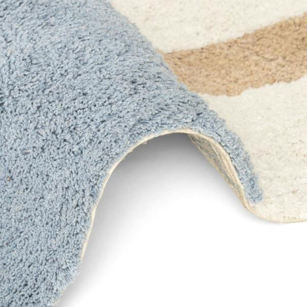 Close-up of a textured blue rug corner on a white background