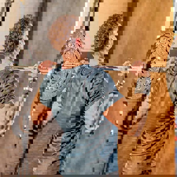 Man lifting a barbell in a gym setting wearing  adidas wrist wraps