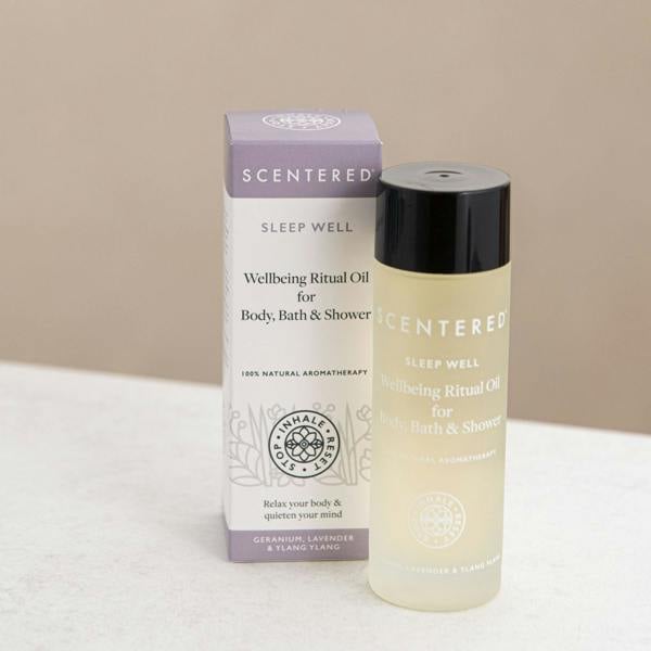 Scentered Sleep Well Body oil in bottle next to it's box on a beige background