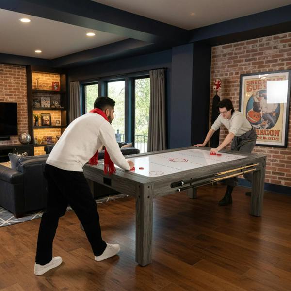 Grey 7-in-1 games table with two storage benches, featuring a smooth surface and players engaged in a game, set in a cozy room
