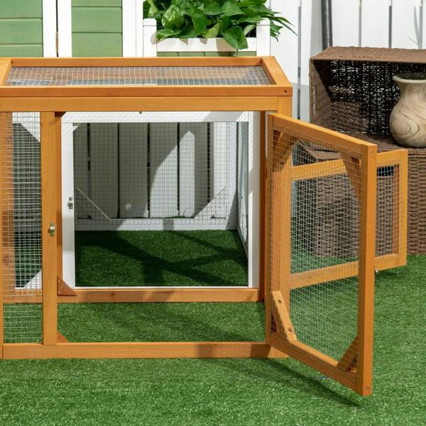 Wooden chicken coop with open side door, wire mesh walls, and grassy interior run