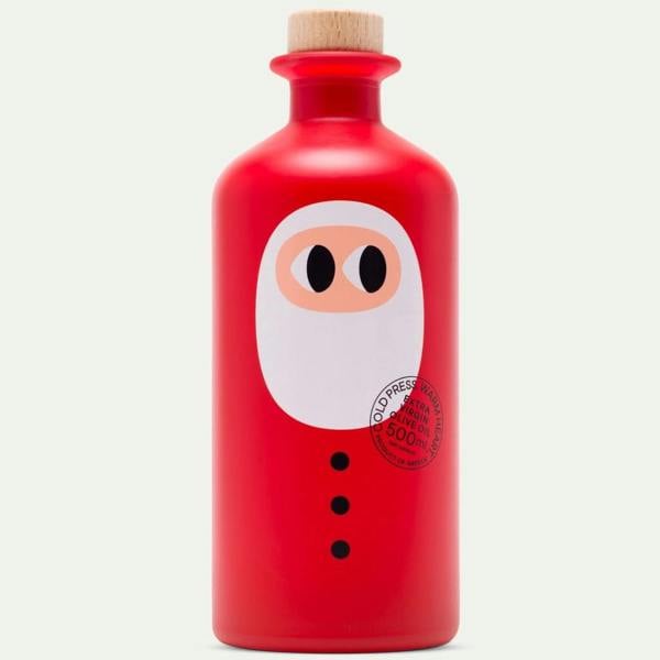 Matte red glass bottle of cold-pressed Greek extra virgin olive oil styled with a minimalist Santa face and wooden stopper.