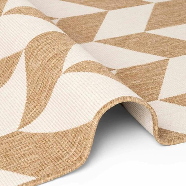 Close-up of a beige and white geometric patterned rug on a light gray background