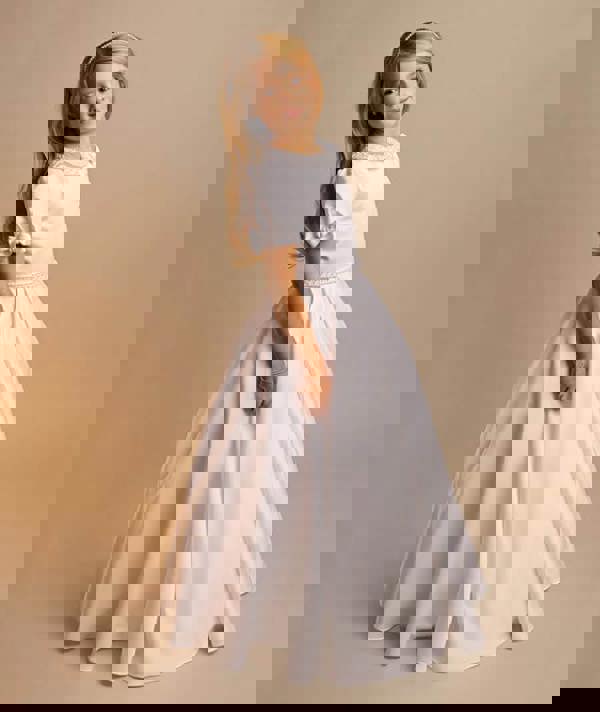 Young girl wearing a white dress with a plain background