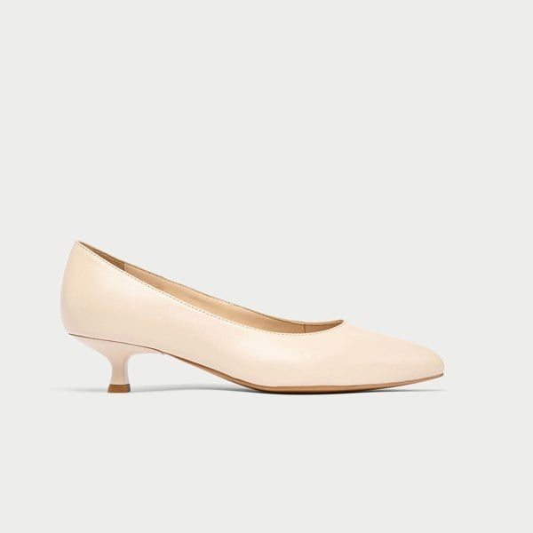 Nude-colored kitten heel shoe on a light gray background