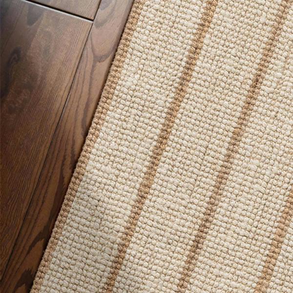 Textured beige rug with vertical stripes on a white background