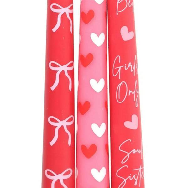 Close-up of three taper candles with bow, heart, and script prints