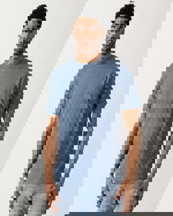 model wearing a Armani Exchange Mens T-Shirt with Small Milano-New York Logo in China Blue